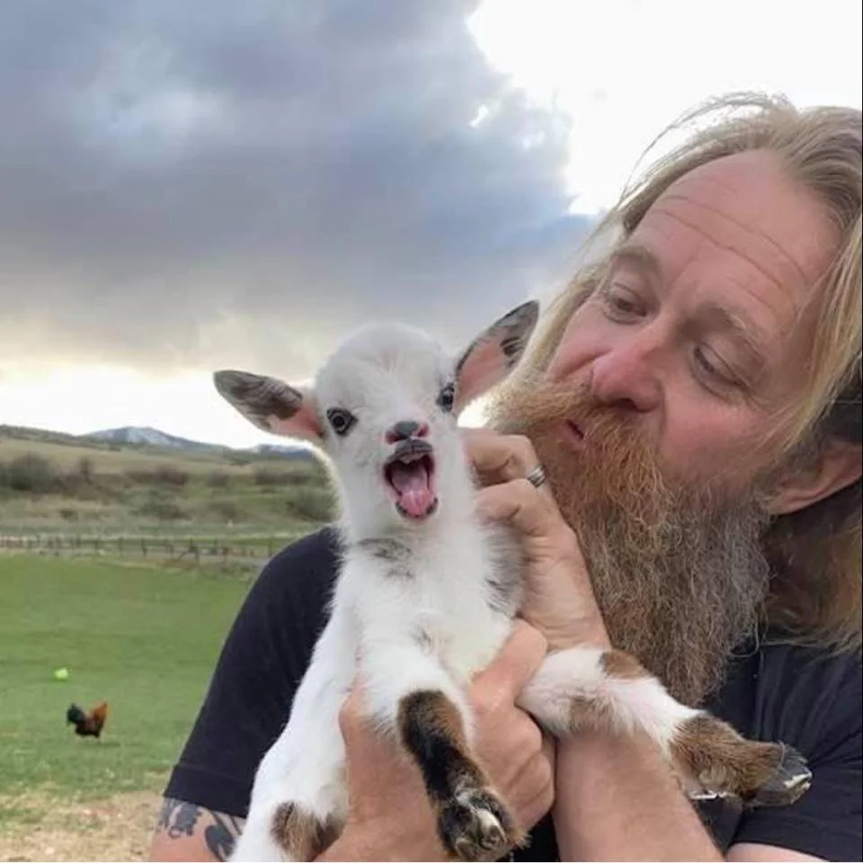 Kimball Roundy, a farmer, with a baby goat